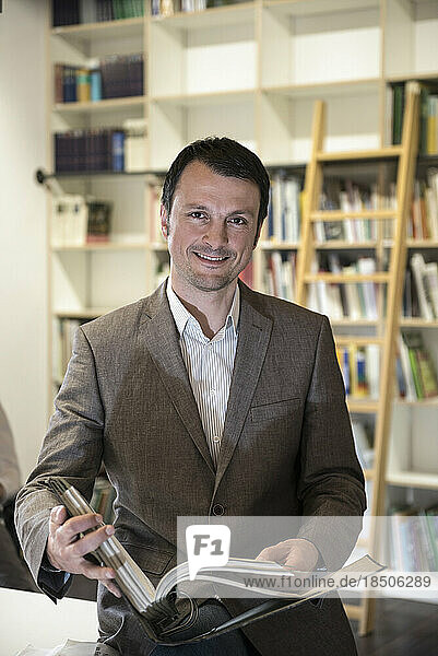 Portrait of a mature businessman holding file in an office  Bavaria  Germany