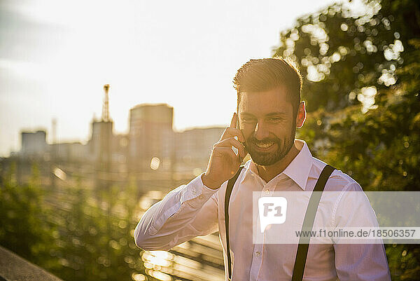 Businessman talking on mobile phone at sunset  Munich  Bavaria  Germany