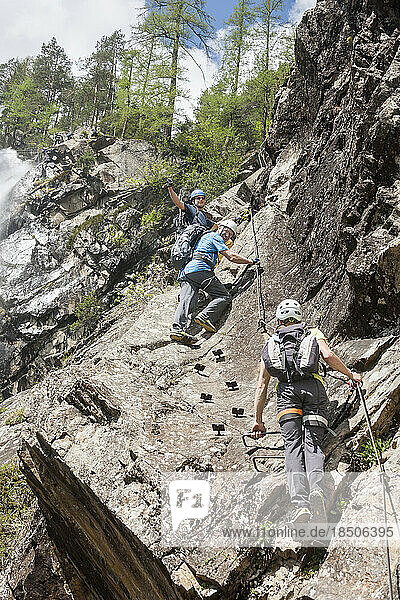 Group of climbers on rock via ferrata towards Lehner Waterfall  Otztal  Tyrol  Austria