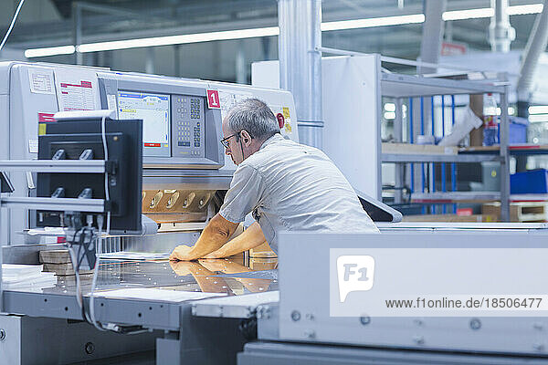 Mature man working in books printing industry  Bremgarten  Hartheim am Rhein  Baden-Wuerttemberg  Germany