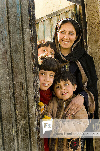 Mother and her three children at the front door of their Kabul home.