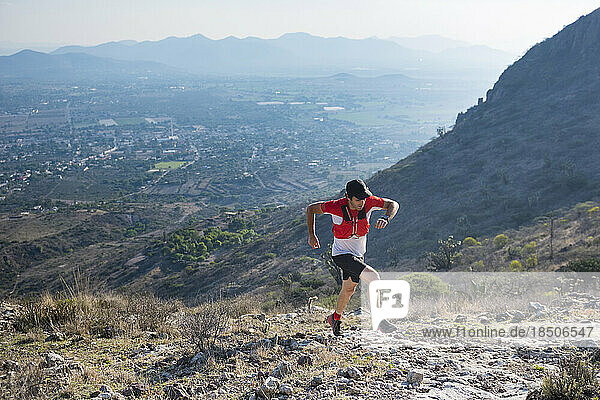 Male trail runner climbing up the mountains in the desertic landscape of El Arenal  Hidalgo  Mexico.