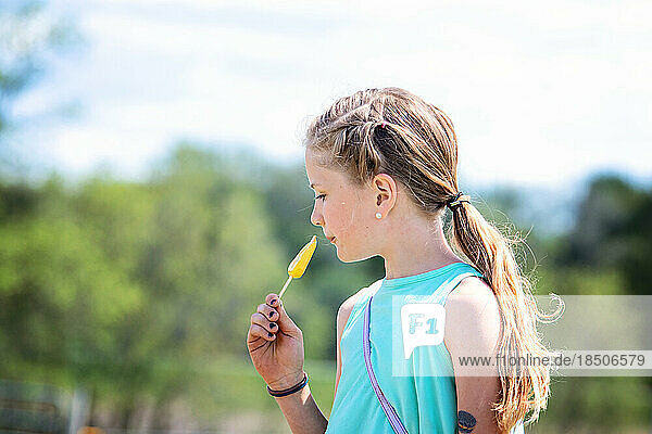 Pretty little blond girl eating a popsicle.