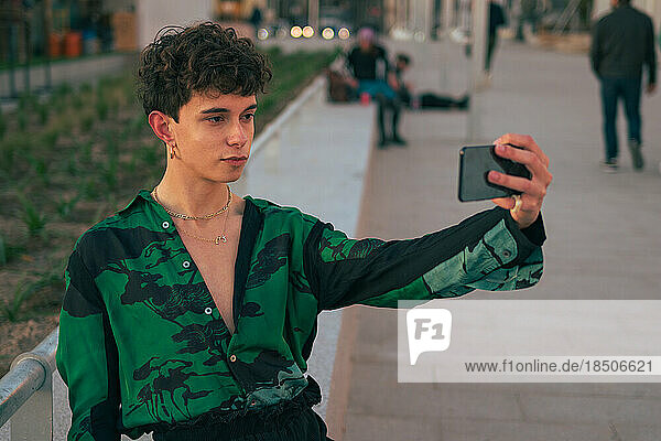 Stylish gay man take a selfie with his mobile phone on the street