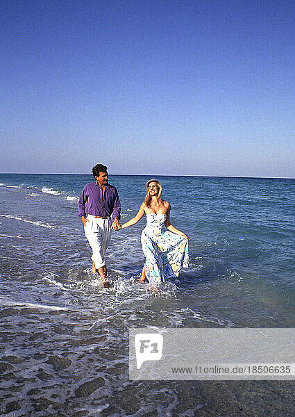 Attractive young couple walking on the beach