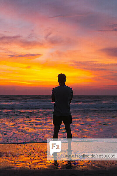Man at sunset  a brightly colored sunset in Bali.
