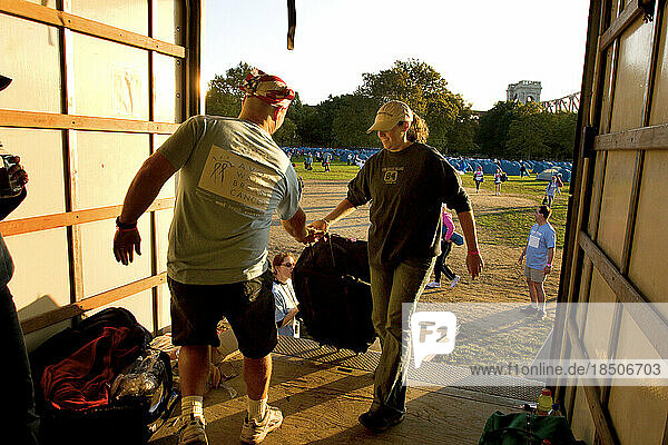 Crew members load gear and suitcases into a truck during the Avon Walk for Breast Cancer in New York City.