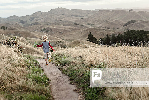 Young child running on a scenic path in New Zealand