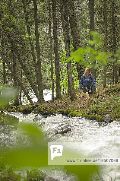 Woman hiking along a creek.
