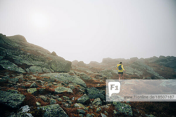 Woman trail running in fog on NH's Presidential Traverse