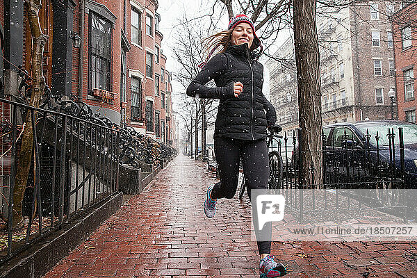 Woman Running and Smiling in Boston During Snowstorm
