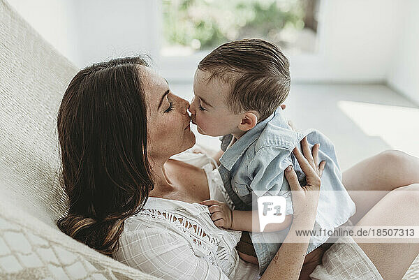 Mother and Son kissing and cuddling in hammock in natural light studio