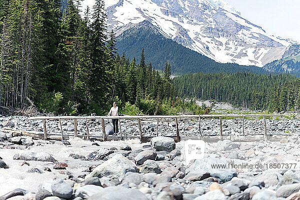 Hiker is standing on the log bridge at Mt Rainier National Park