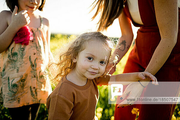 Two Year Old Smirking at Camera in Field in San Diego