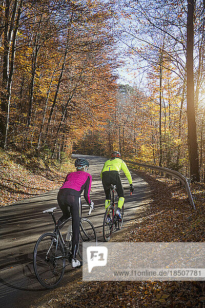 Couple riding roadbike on street in autumn  Bavaria  Germany