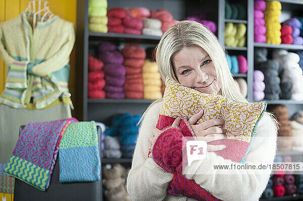 Portrait of a mature woman hugging cushion in coffee shop  Bavaria  Germany