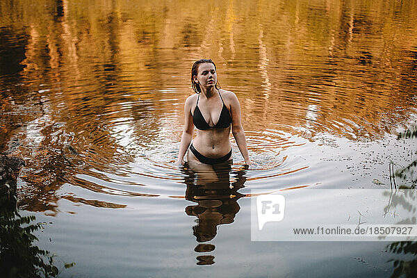 Seductive woman in a bikini walking in lake