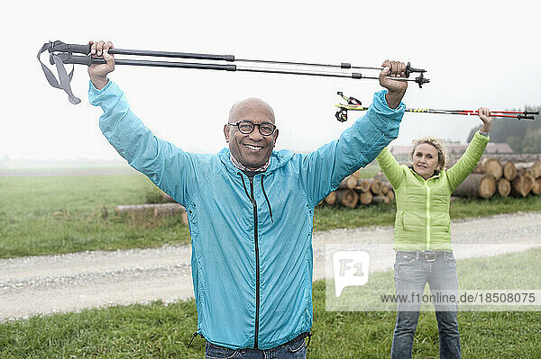Senior couple stretching before Nordic walk with hiking poles  Bavaria  Germany