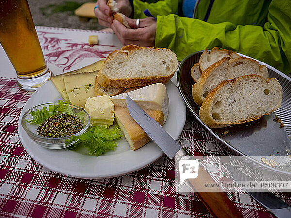 Person eating cheese and baguette meal on table  Vosges  France