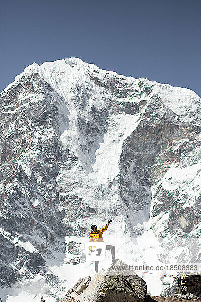 A man poses under the mountains on the Everest Base Camp Trek.