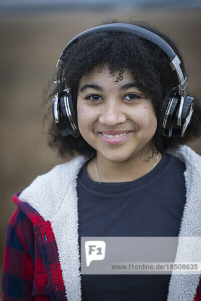 biracial teen girl wearing headphones and smiling
