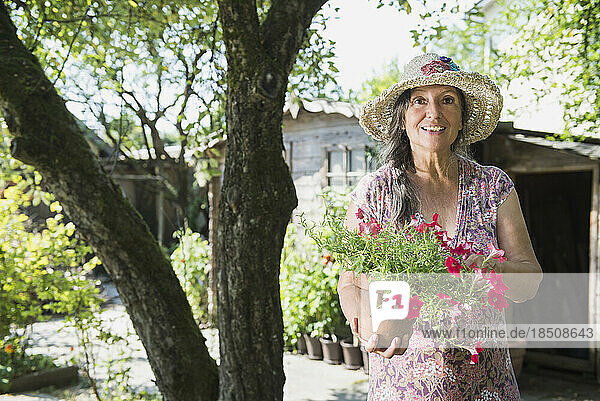 Senior woman with pot of flowers  Altötting  Bavaria  Germany