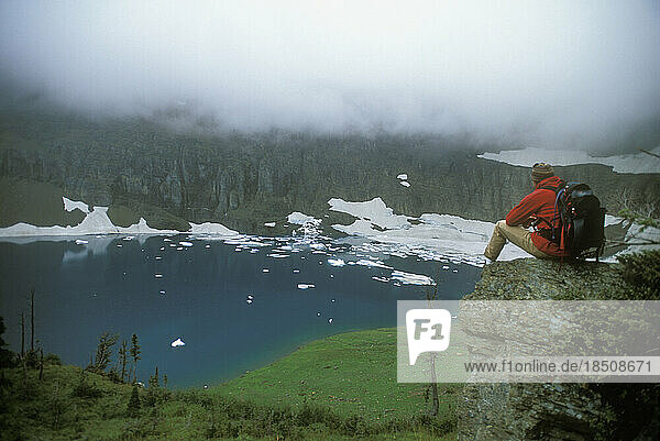Man hiking overlooking Glacier Lake in Glacier Park  Montana.