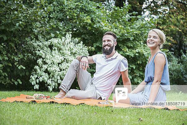 Young couple enjoying picnic in garden  Bavaria  Germany