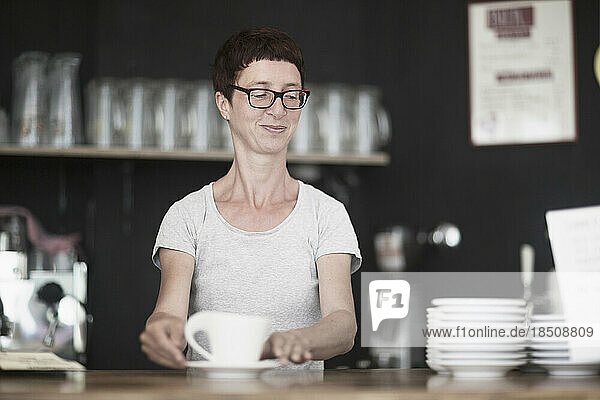 Mature woman drinking coffee in coffee shop  Freiburg im Breisgau  Baden-Württemberg  Germany