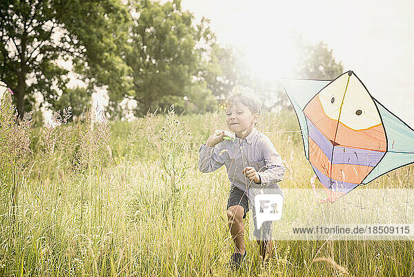 Little boy running with kite on meadow in countryside  Bavaria  Germany