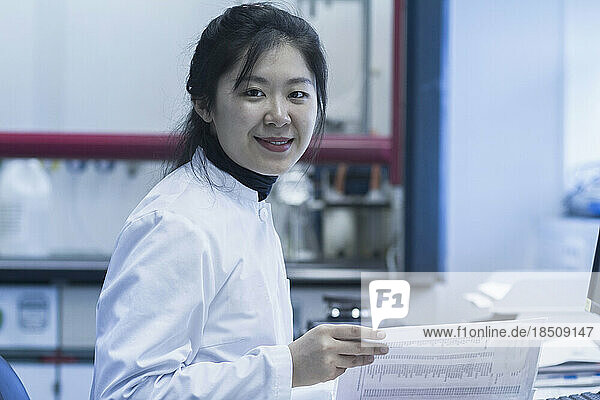 Portrait of a young female scientist checking report in a laboratory  Freiburg im Breisgau  Baden-Württemberg  Germany