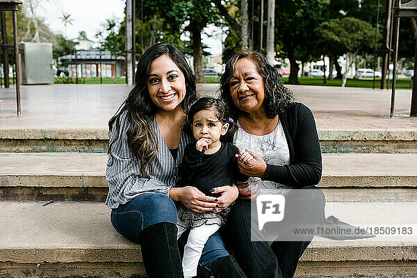 Three generations of women smiling for camera in park