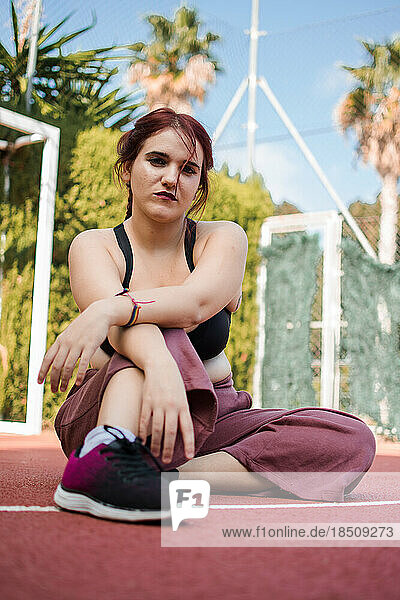 Young woman posing with urban clothes is a basketball court