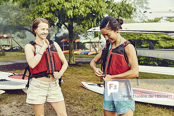 Two young women getting ready to go standup paddle boarding