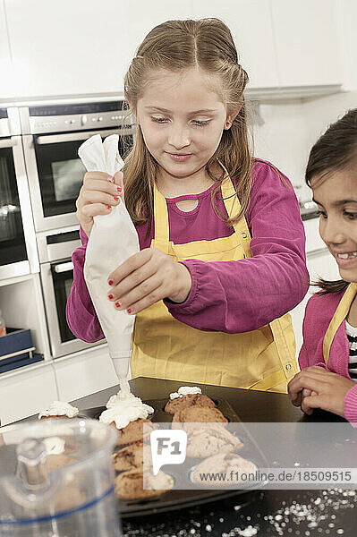 Schoolgirl icing on muffins with icing bag in home economics class  Bavaria  Germany
