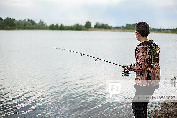 Boy fishing in pond by himself