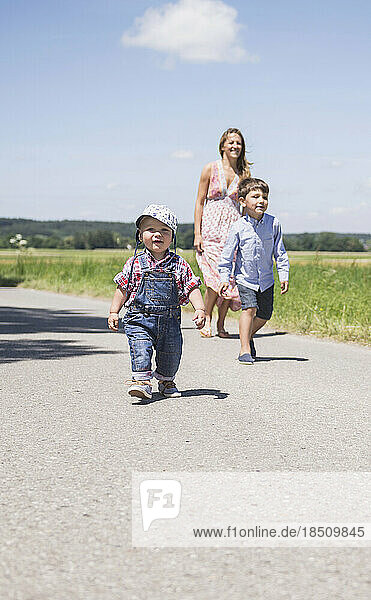 Woman with his son walking on road in the countryside  Bavaria  Germany