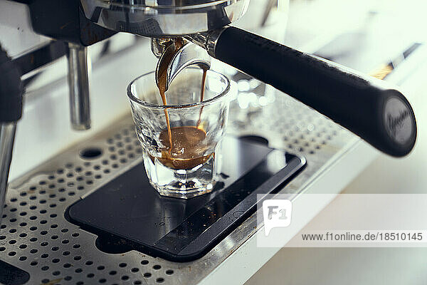 A single espresso shot being pulled from an espresso machine.