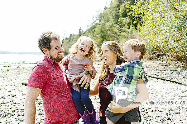 Closeup straight on portrait of a happy family of four on the beach