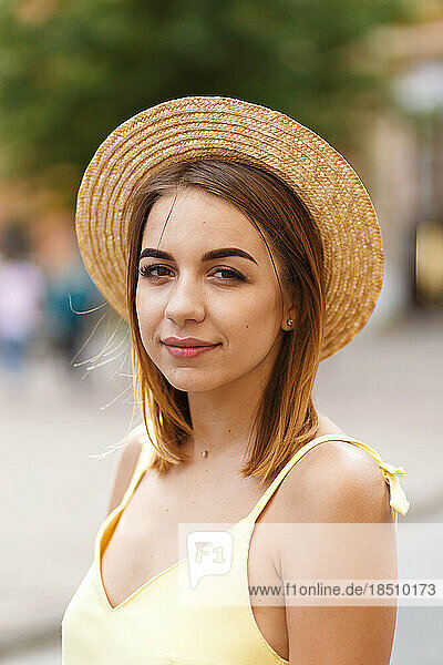 Young tourist girl in a yellow dress and a hat in the summer