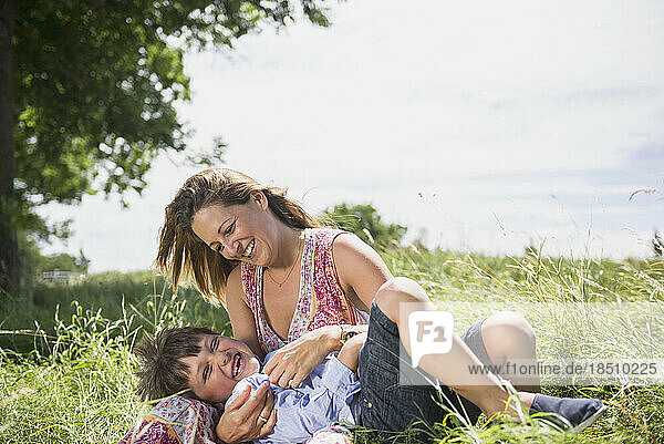 Woman with her son playing on grass and enjoying picnic  Bavaria  Germany
