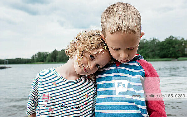 portrait of siblings hugging at the beach in summer on vacation