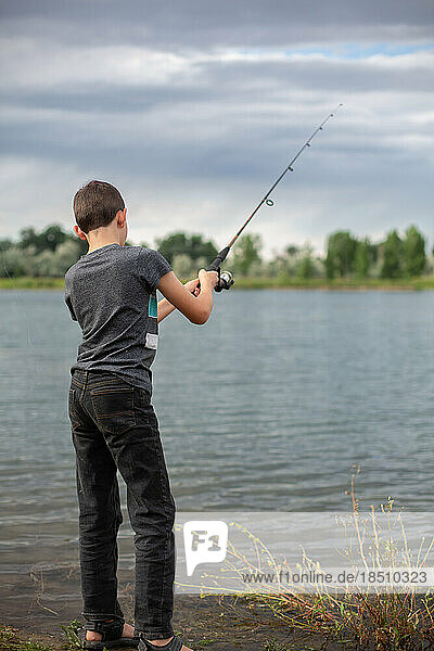 Tween boy fishing in pond