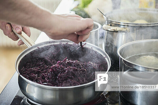 Chef cooking red cabbage on stove