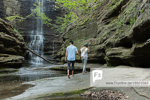 A couple walking towards a waterfall at Matthiessen State Park