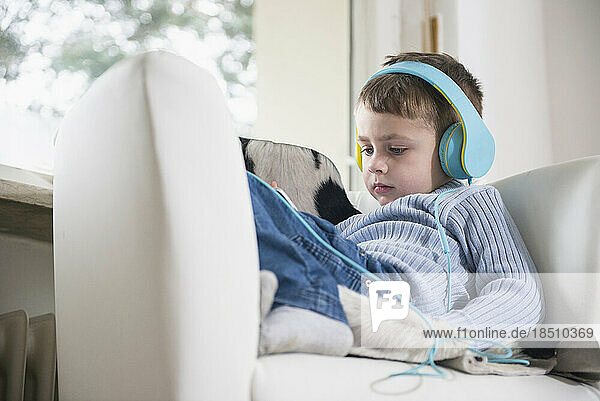 Boy listening music using mobile phone and headphones