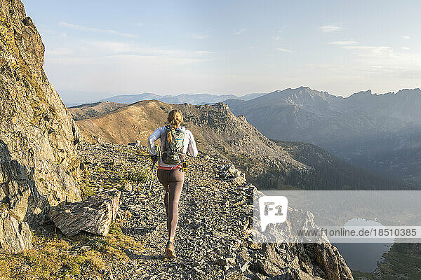 A young woman enjoys an early morning trail run high up in the Rocky M