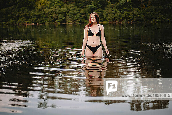 Front view of young woman standing in lake