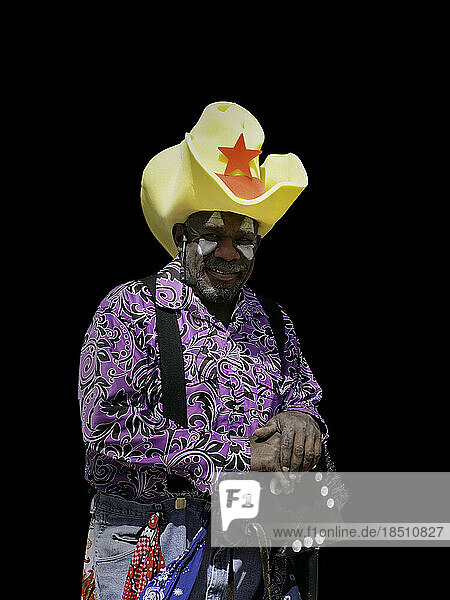 Portrait of a rodeo clown against black in available light