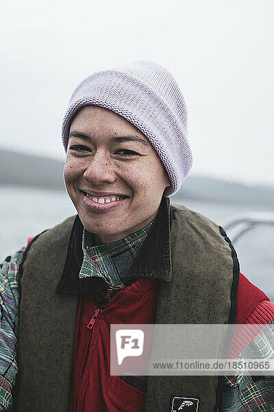 Goofy smile of mixed race queer woman on boat trip in Scotland